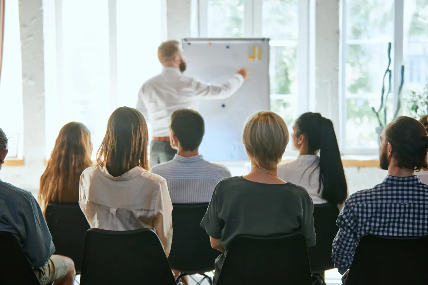Männlicher Redner hält einen Vortrag bei einem Geschäftstreffen. Publikum im Konferenzsaal. Symposium über Wirtschaft und Unternehmertum.